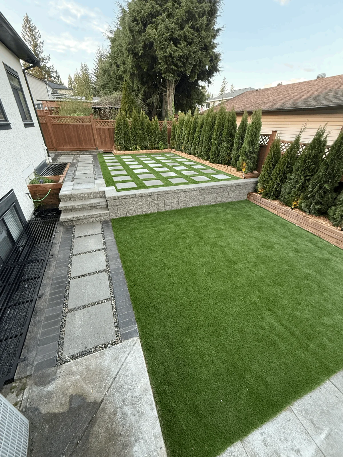 Detail of the stone edging separating lawn and paver walkway.