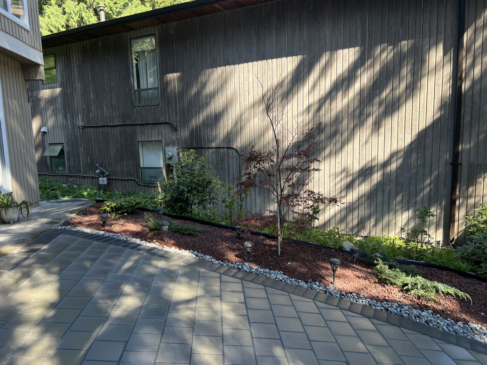 Wide view of the completed driveway and planted border.